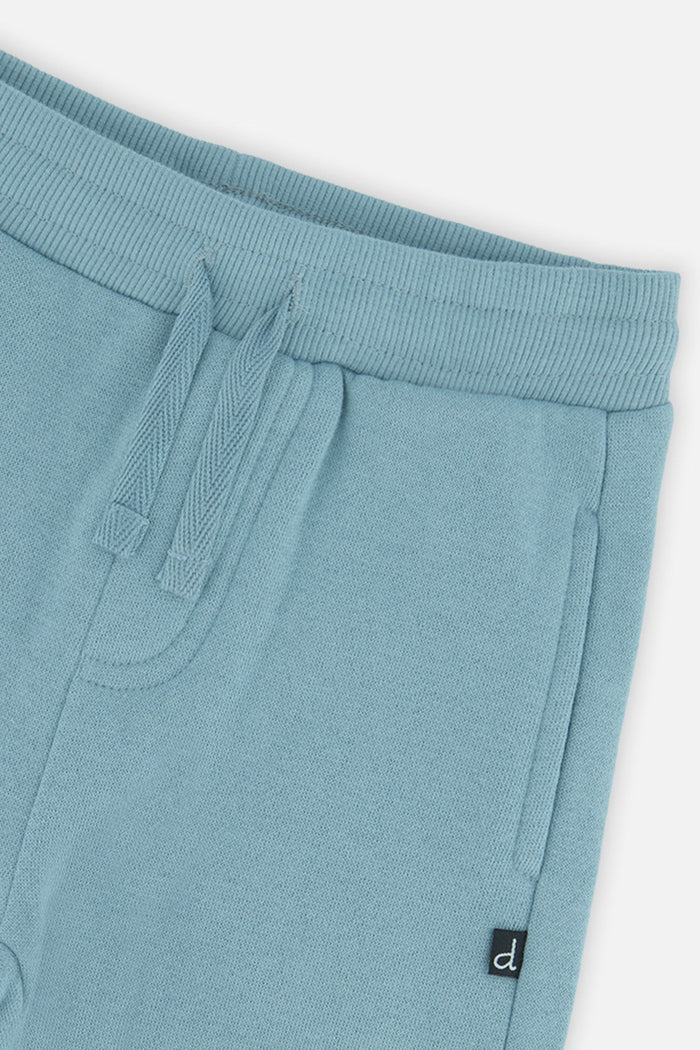 Close-up of the drawstring waist and side pocket on the pale turquoise baby sweatpants