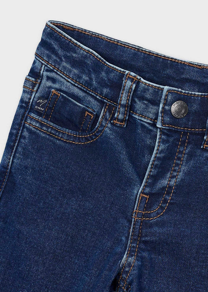 Close-up of the waistband, button and front pocket on the dark wash Mayoral jeans