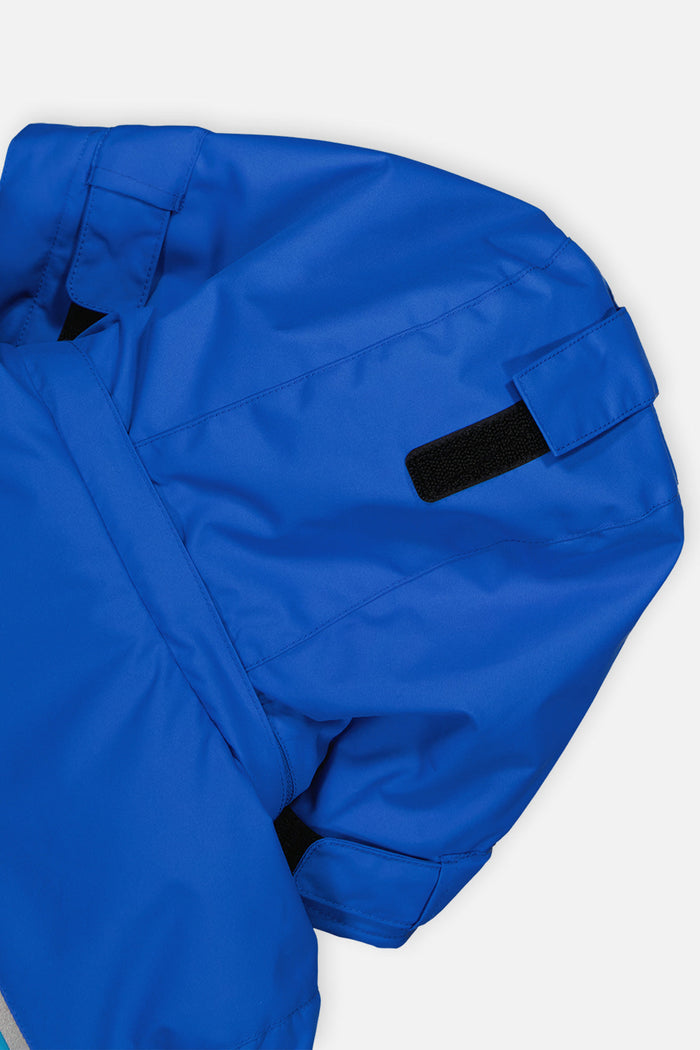 Close-up of the royal blue sleeve and shoulder of the Deux par Deux PLAY snowsuit