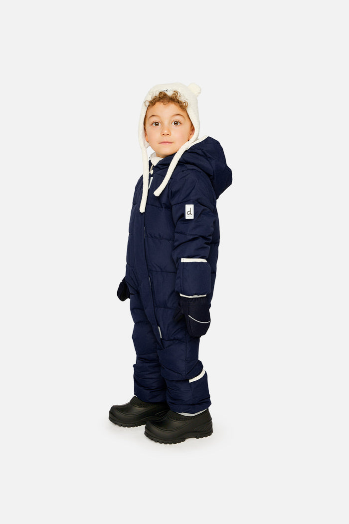 Side view of a child in the dark blue Baby Cloud one-piece snowsuit