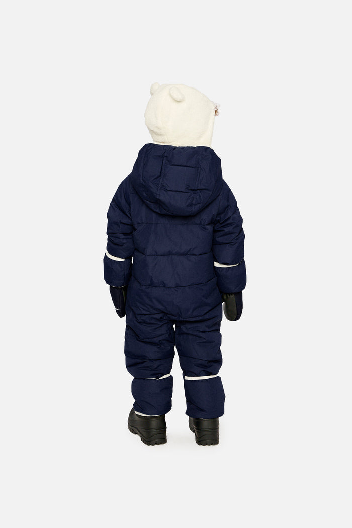 Back view of a child in the dark blue Baby Cloud snowsuit