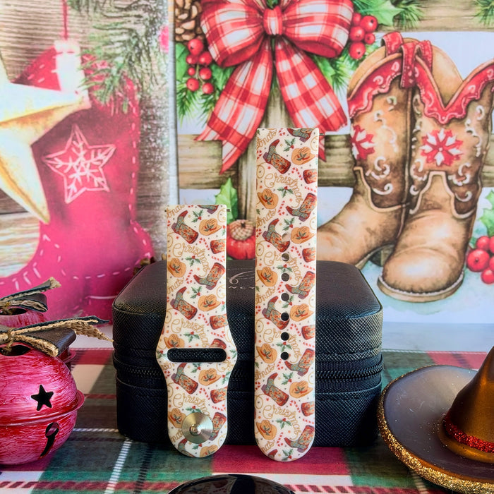 Both straps of the Boot Scootin' Christmas silicone Samsung Galaxy Watch band on a black jewelry box with a red jingle bell