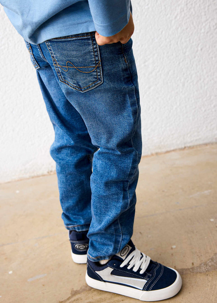 Back pocket detail of the medium wash Mayoral jeans on a child