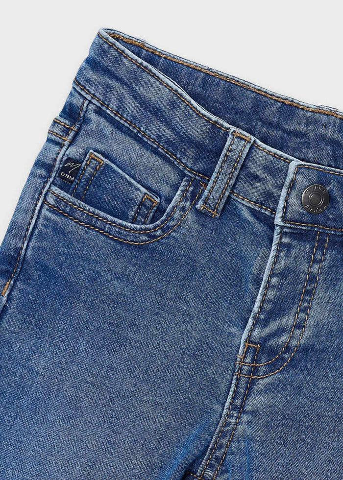 Close-up of the waistband, button and front pocket on the medium wash Mayoral jeans