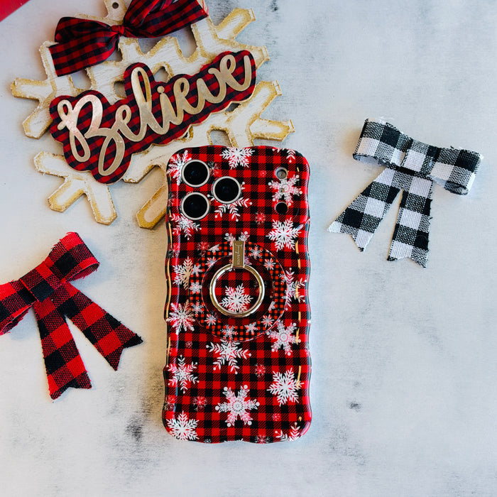 Buffalo Plaid Snowflake MagSafe grip ring attached to the matching iPhone case, with a Believe sign and buffalo check bows