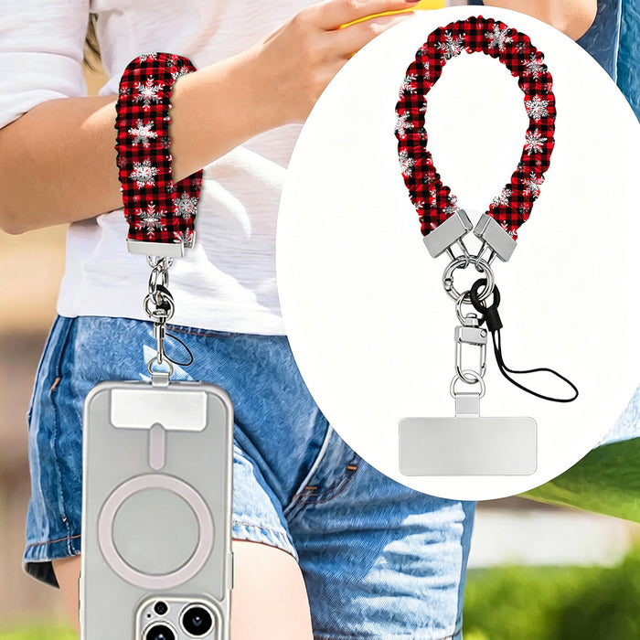 Buffalo Plaid Snowflake scrunchie phone strap worn on the wrist with an iPhone hanging from it, plus close-up of the strap and phone tab