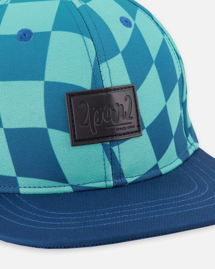 Deux par Deux boys' teal checkerboard print flat-brim cap – close-up of the logo patch and print