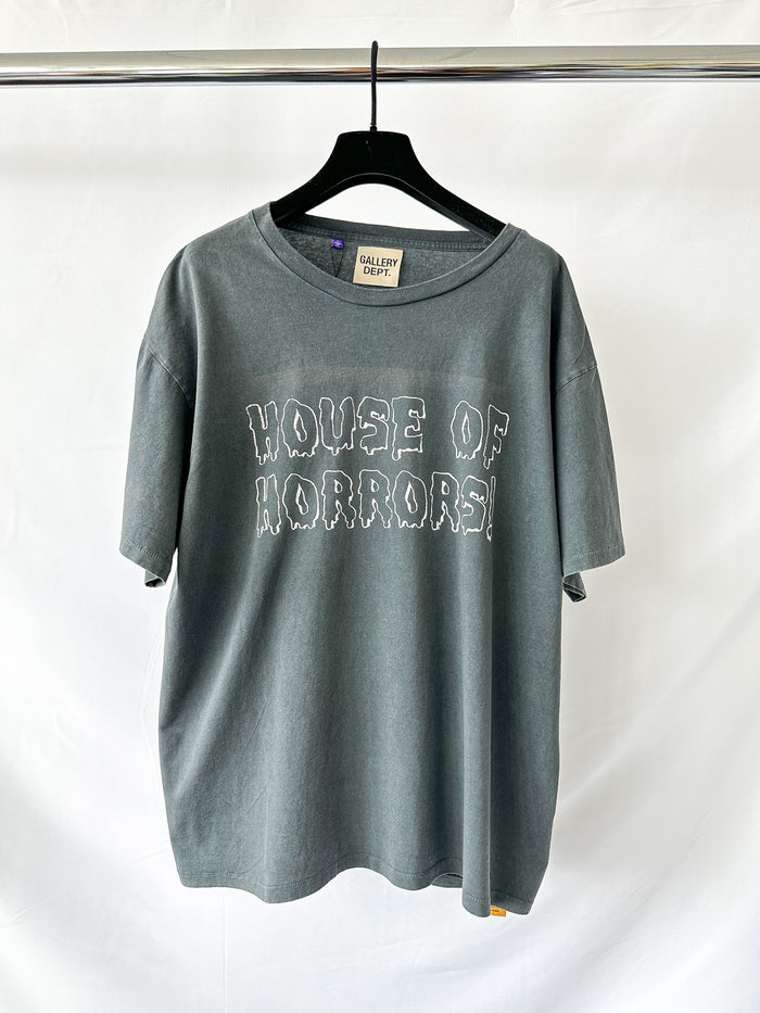 Gray t-shirt with 'HOUSE OF HORRORS' text on a hanger against a white background