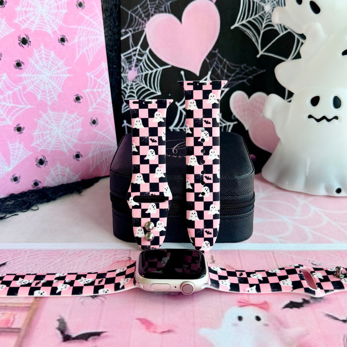 Hey Boo, Looking Cute silicone Apple Watch band standing upright with an Apple Watch at its base, pink and black checkerboard with white ghosts.