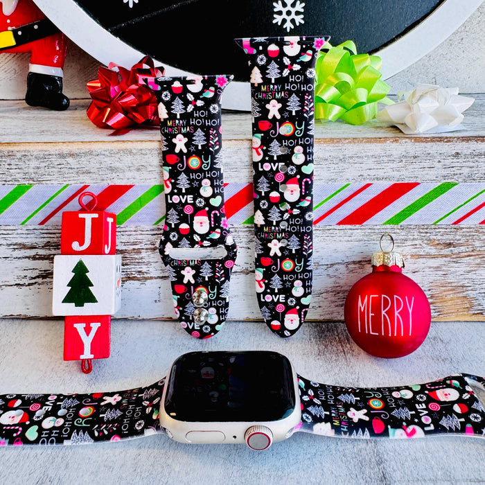 Jolly Wrist-mas Apple Watch band attached to an Apple Watch, with JOY blocks and a red Merry ornament