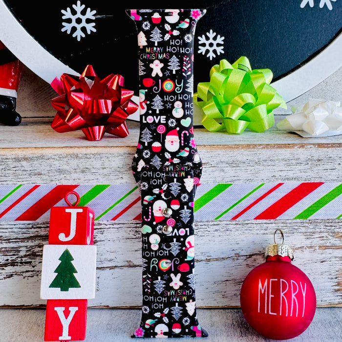 Single Jolly Wrist-mas Apple Watch band strap beside JOY blocks and a red Merry ornament