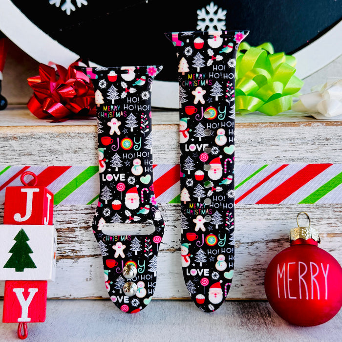 Both Jolly Wrist-mas Apple Watch band straps standing with JOY blocks and a Merry ornament on striped ribbon