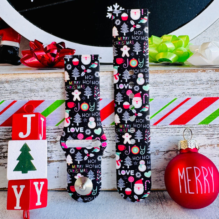 Both Jolly Wrist-mas Samsung Galaxy Watch band straps standing beside JOY blocks and a red Merry ornament