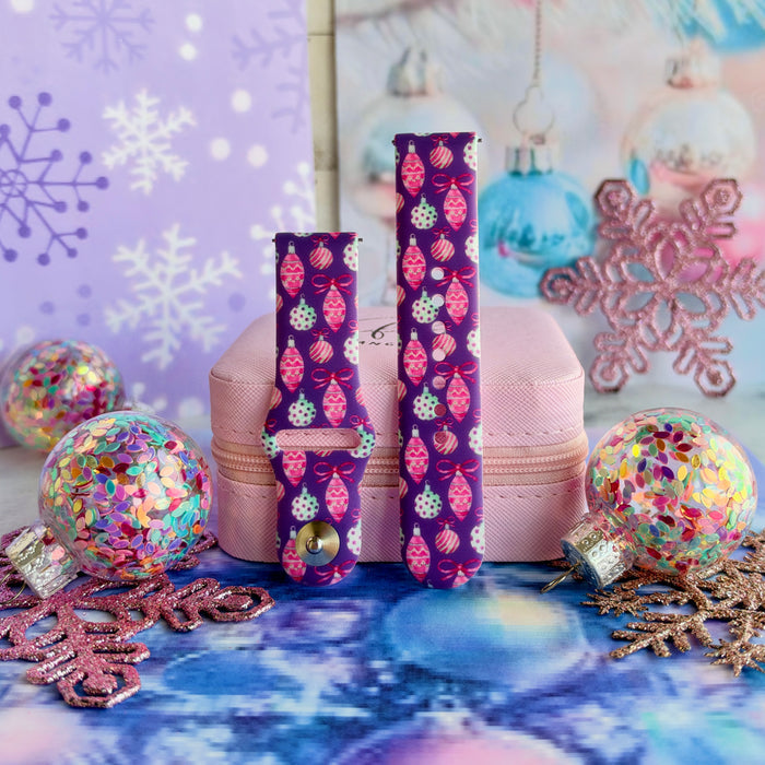 Just One More Ornament Samsung Galaxy Watch band buckled and standing on a pink jewelry box between confetti ornaments and pink glitter snowflakes