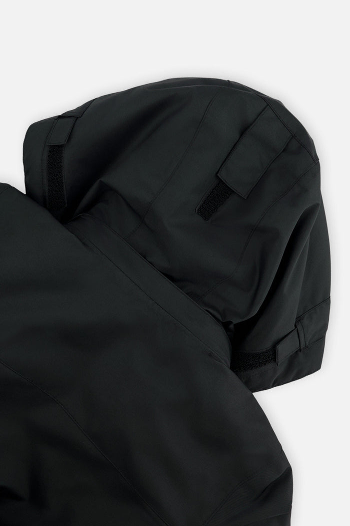 Close-up of the helmet-compatible hood on the black Deux par Deux TEKNIK snowsuit