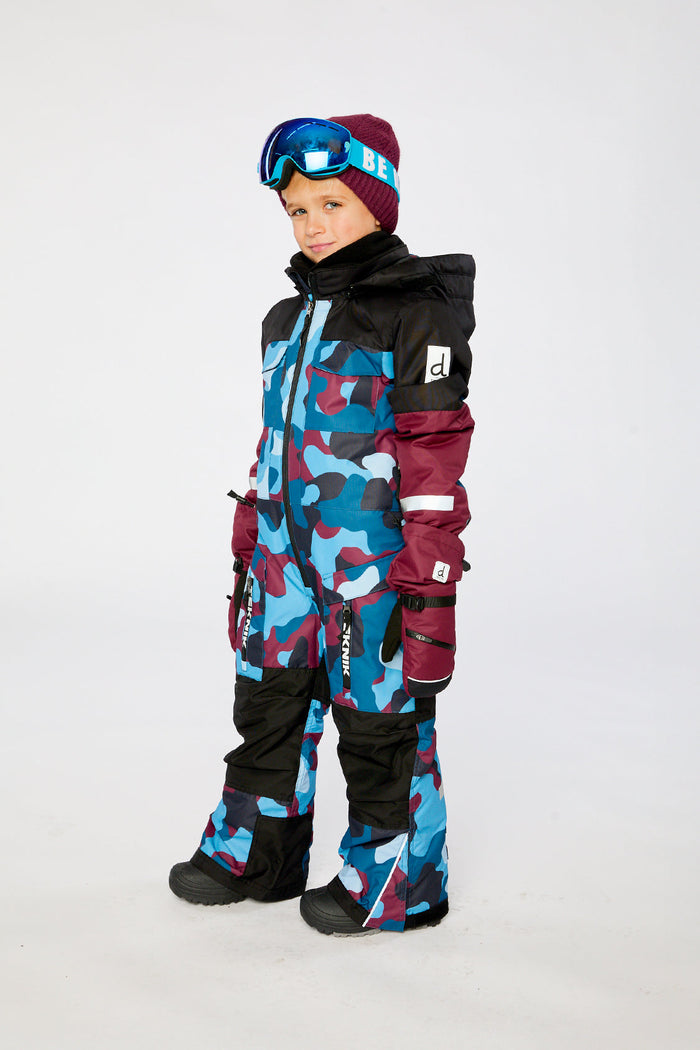 Child wearing the blue and red camouflage Deux par Deux TEKNIK one-piece snowsuit, side view