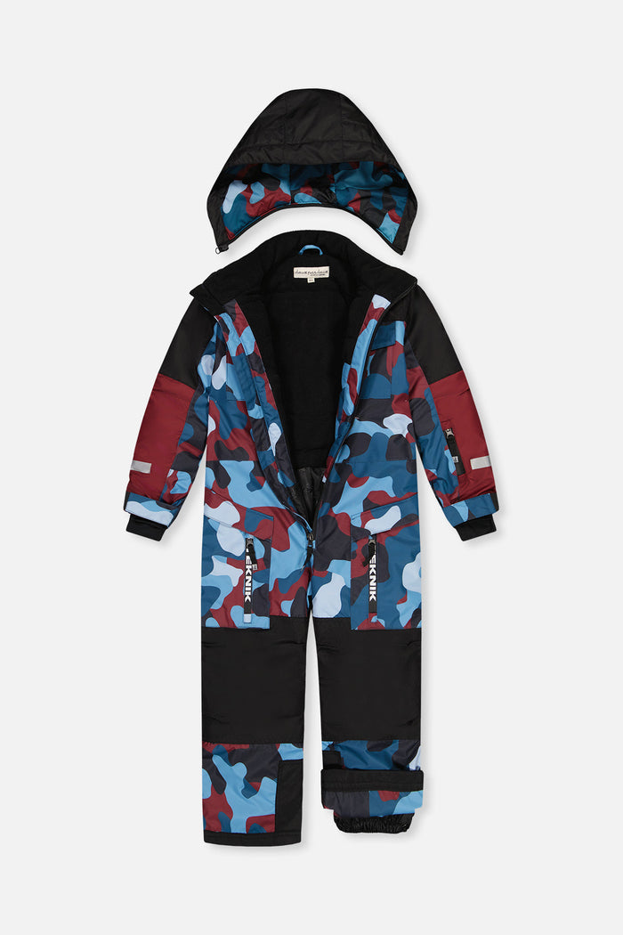 Blue and red camouflage TEKNIK one-piece unzipped with the black hood detached, showing the lining