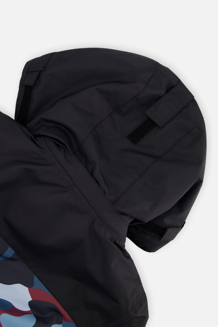 Close-up of the black helmet-compatible hood on the camouflage Deux par Deux TEKNIK snowsuit