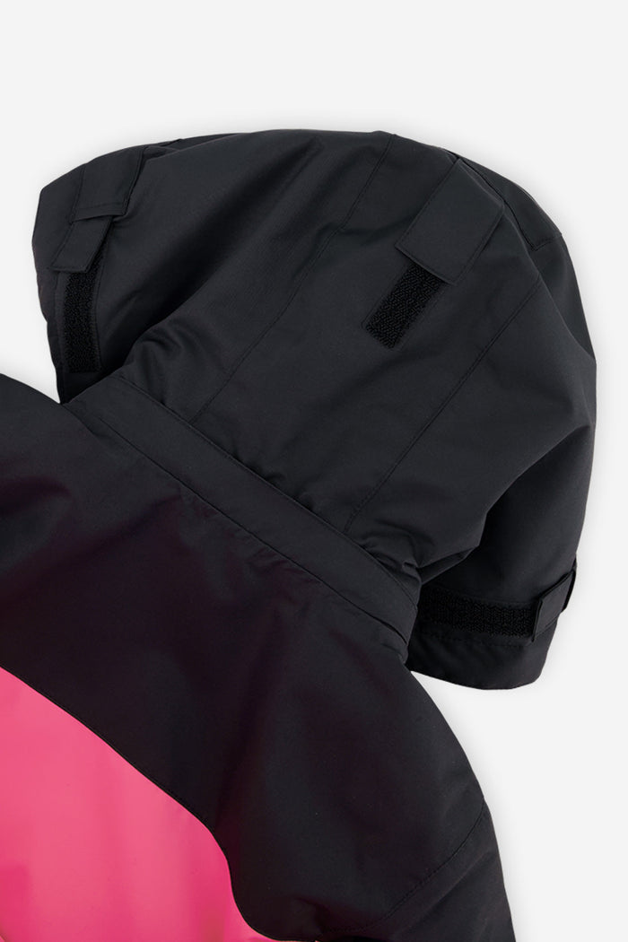 Close-up of the black helmet-compatible hood on the bright pink Deux par Deux TEKNIK snowsuit
