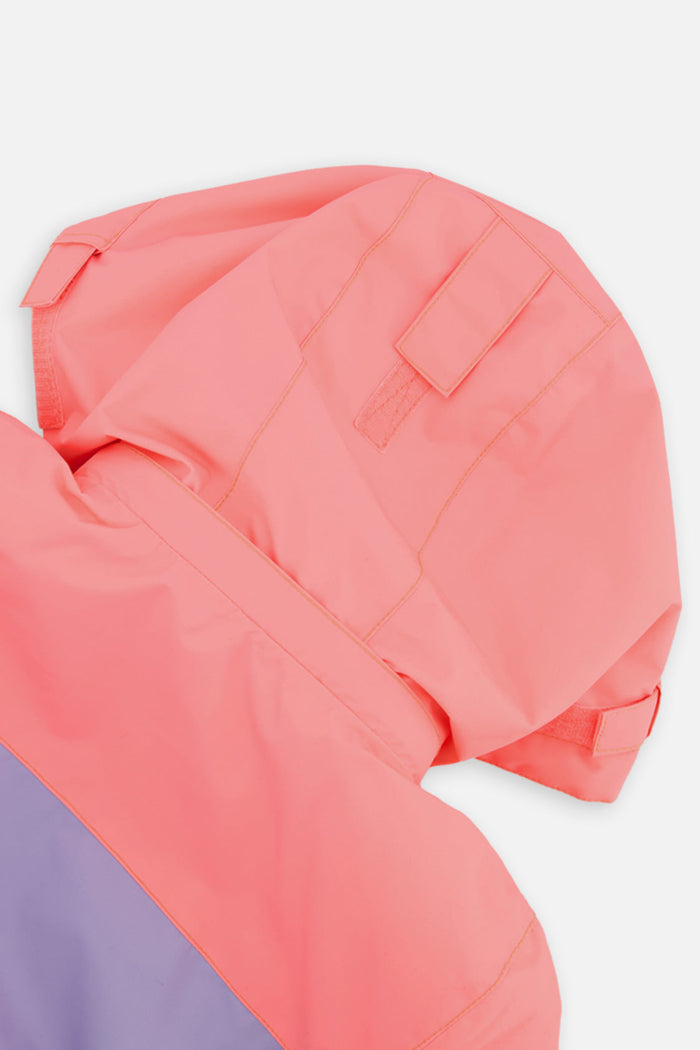 Close-up of the orange helmet-compatible hood on the Deux par Deux TEKNIK one-piece snowsuit
