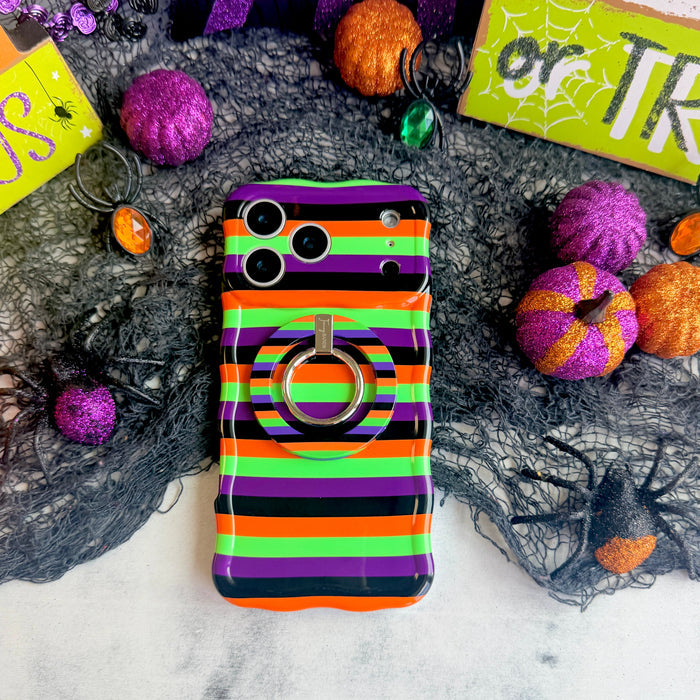Main Witch Energy Hold It Fancy MagSafe grip ring attached to the matching striped iPhone case, styled with glitter pumpkins and a spider