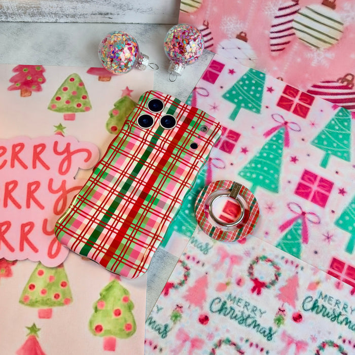 Merry Little Plaid Hold It Fancy MagSafe grip ring snapped onto the matching plaid iPhone case, on a pink and mint Christmas tree backdrop