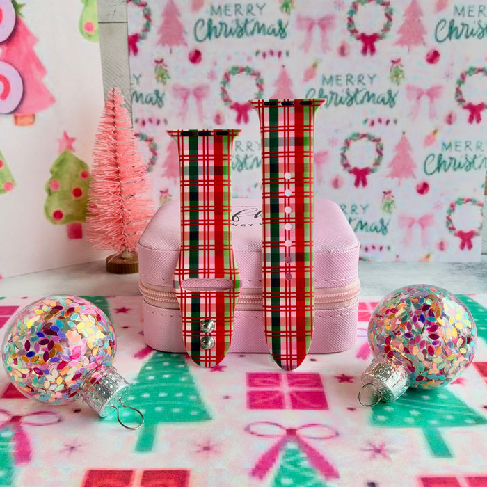 Merry Little Plaid Apple Watch band straps with glitter ornaments and a pink bottle-brush tree on Christmas tree paper