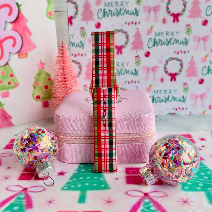 Merry Little Plaid Samsung Galaxy Watch band assembled and standing upright between glitter ornaments