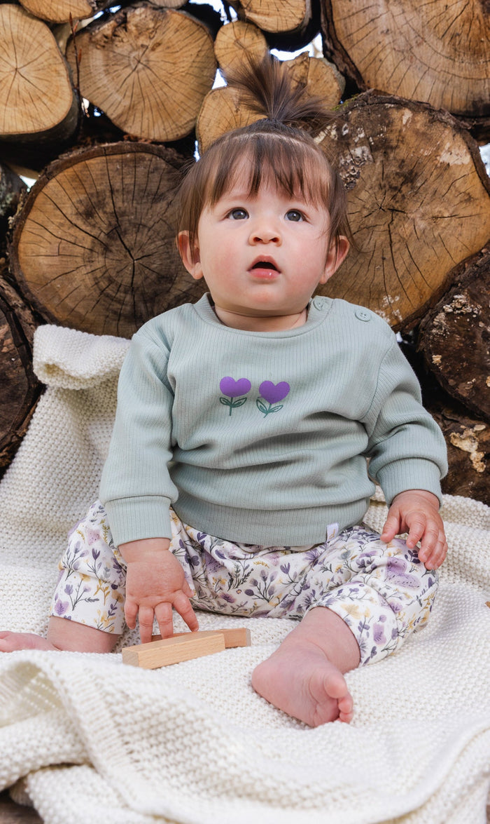 Deux par Deux baby girls ribbed top and pants set, green and beige hearts, lifestyle view