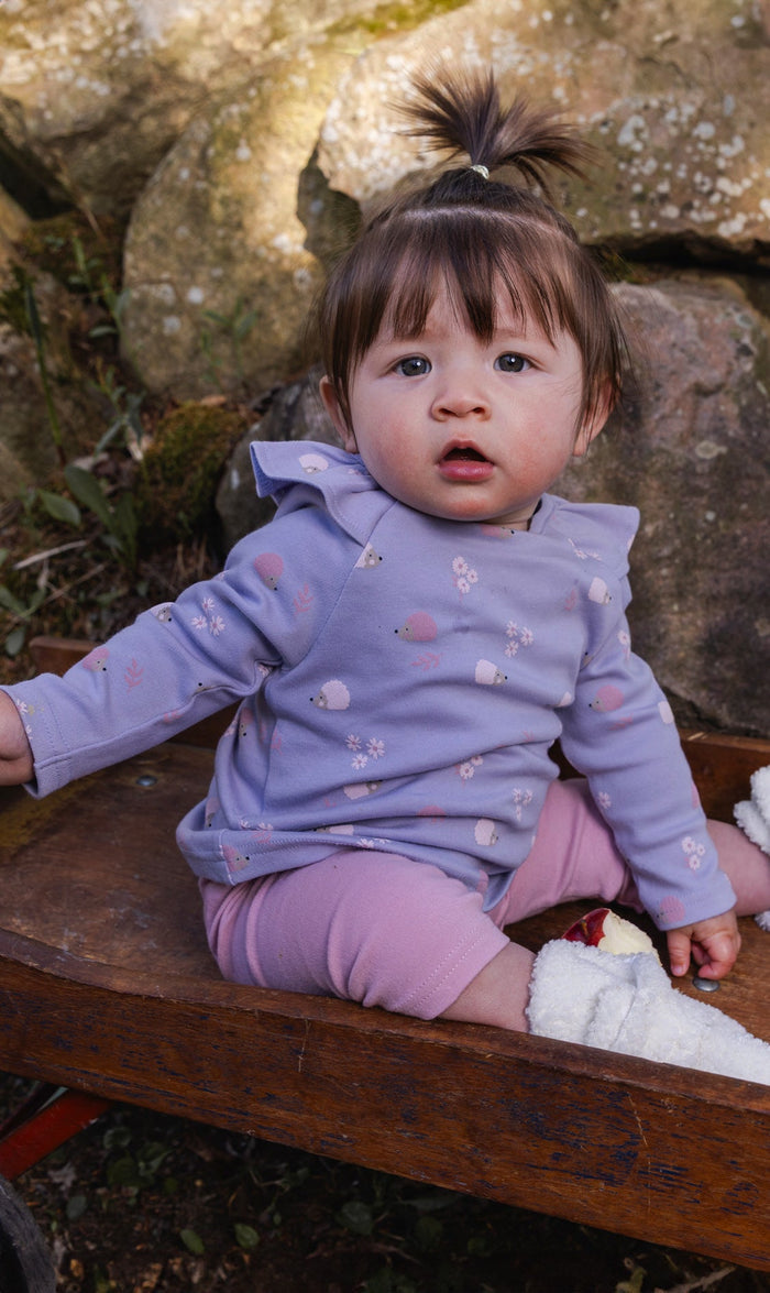 Baby wearing the Deux par Deux purple hedgehog print tunic and dusty pink leggings set, view 2