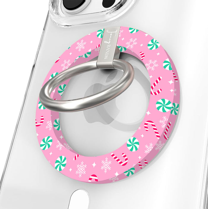 Close-up of the Peppermint Cutie MagSafe grip ring, pink with mint peppermints and candy canes, with a brushed silver ring on a clear iPhone case