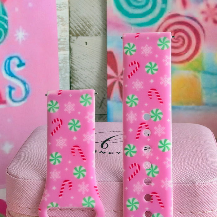 Both straps of the Peppermint Cutie silicone Samsung Galaxy Watch band standing on a pink box in front of a candy backdrop