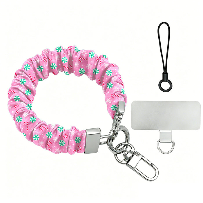 Peppermint Cutie scrunchie phone wrist strap laid flat with silver clasp and phone tab, pink with mint peppermints and candy canes