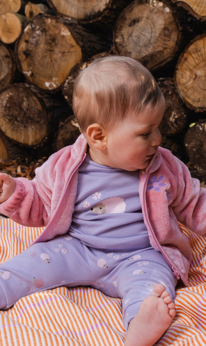 Baby wearing the dusty pink Deux par Deux plush jacket