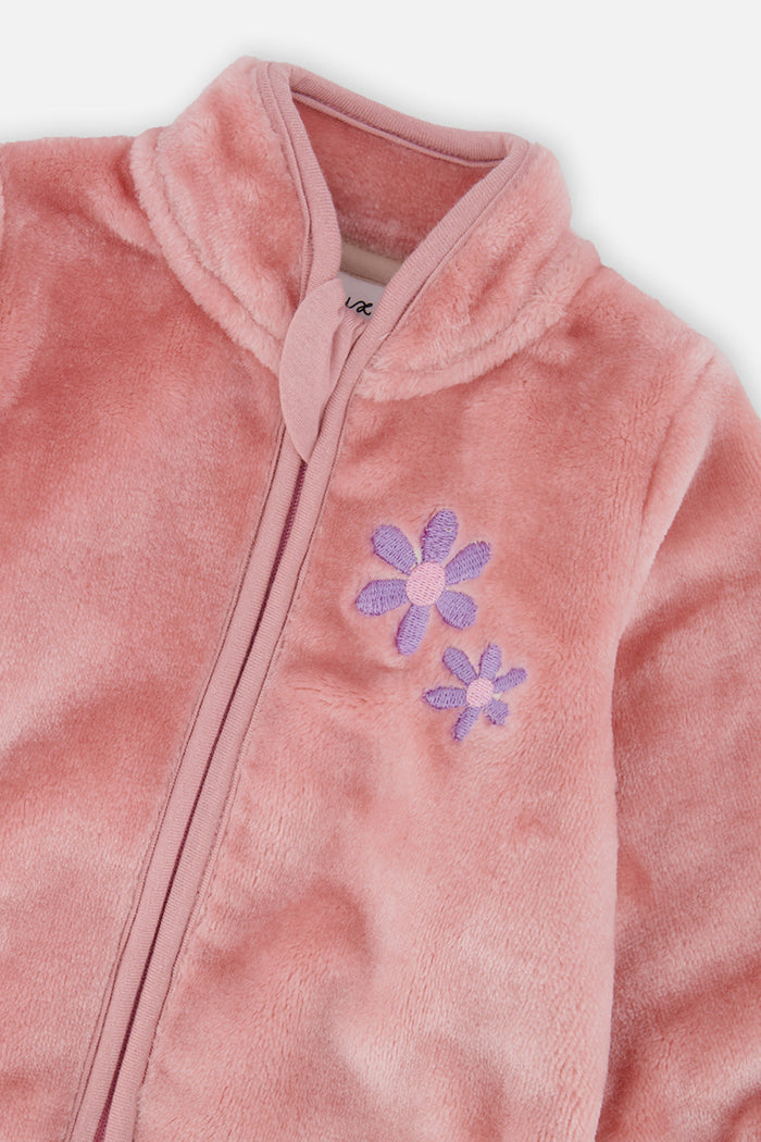 Close-up of the stand-up collar, zipper and flower embroidery on the pink plush jacket