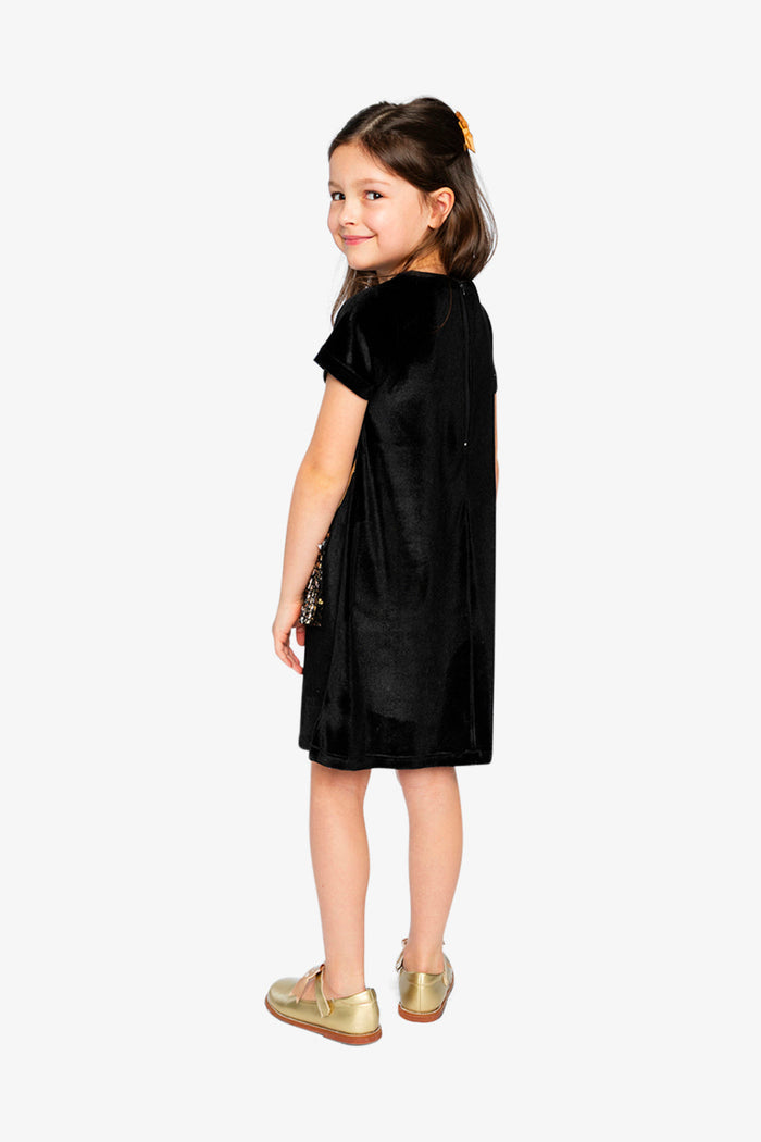 Child wearing the sleeveless black and gold dress with gold bag appliqué
