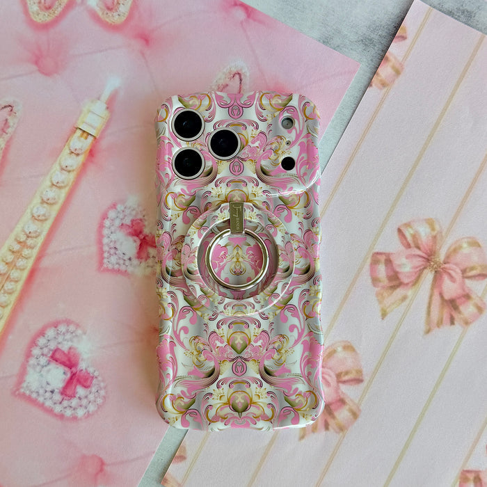 The Pink Heiress pink and gold baroque MagSafe grip ring attached to the matching damask iPhone case, styled on pink bow paper with a pearl Eiffel Tower.