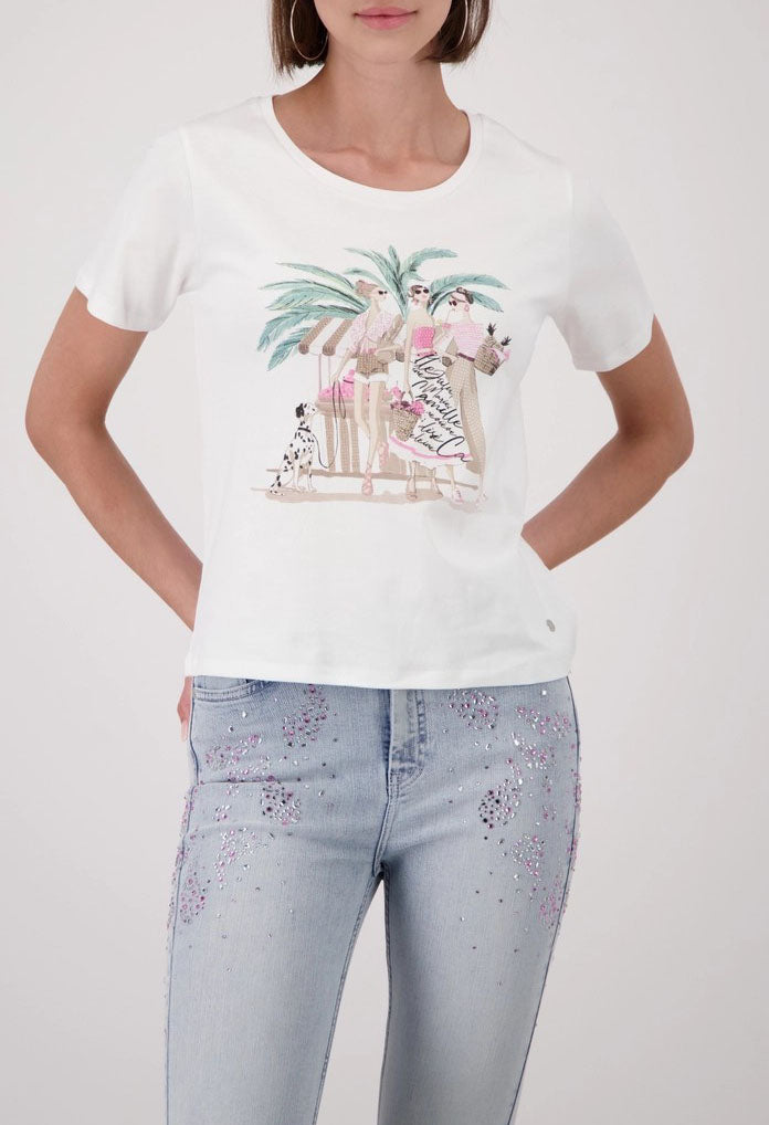 Woman wearing a white t-shirt with a graphic design and light blue jeans on a white background