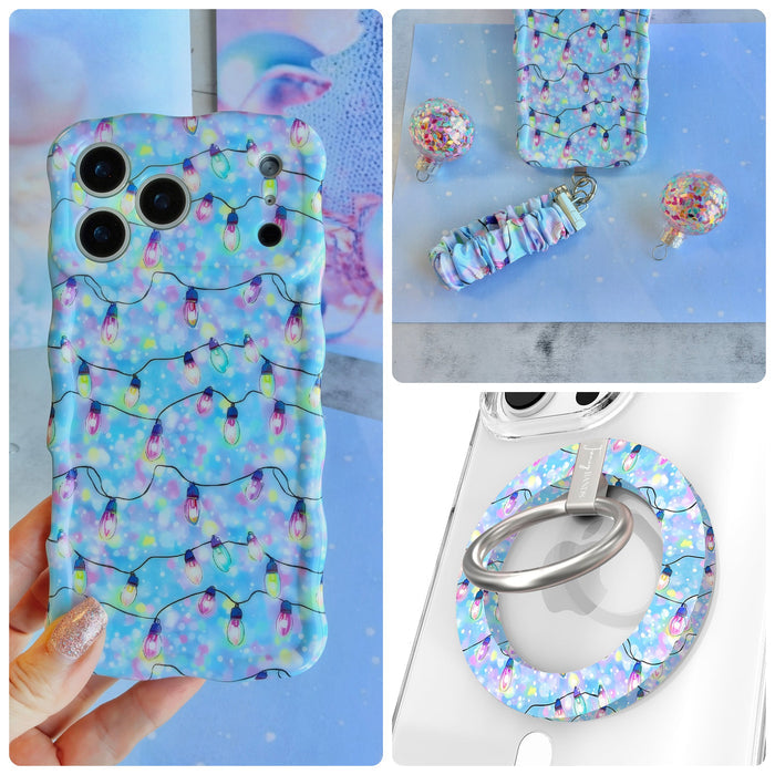 Twinkle All The Way iPhone Matching Set - pastel blue MagSafe case with pink, violet and aqua Christmas string lights, matching Hold It Fancy grip ring and scrunchie phone wrist strap from Fancy Bands