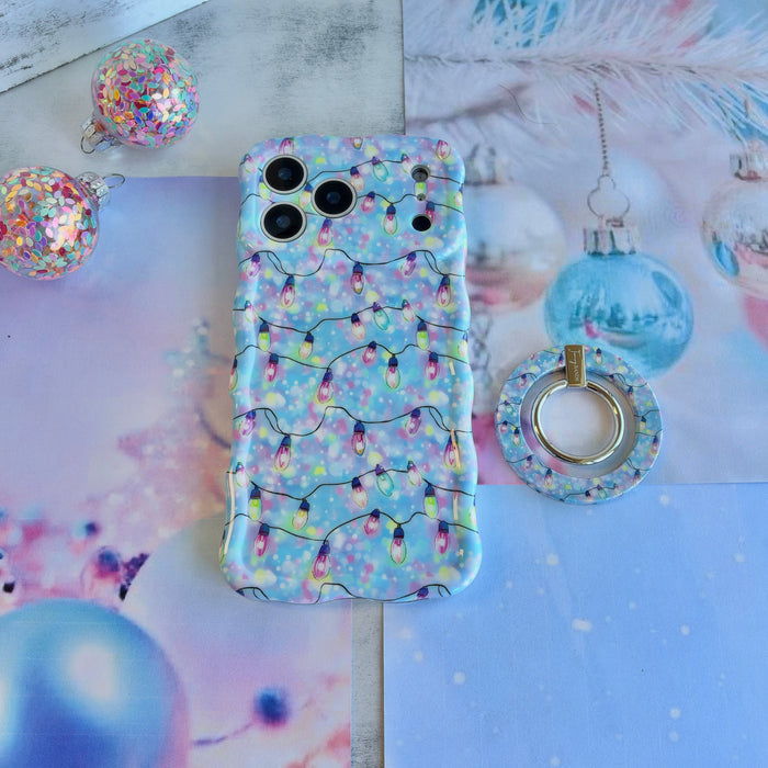 Twinkle All The Way Hold It Fancy MagSafe grip ring beside the matching Christmas lights iPhone case and a blue glass ornament