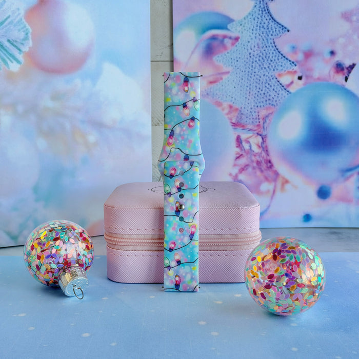Twinkle All The Way Samsung Galaxy Watch band buckled and standing on a pink jewelry box between glitter ornaments