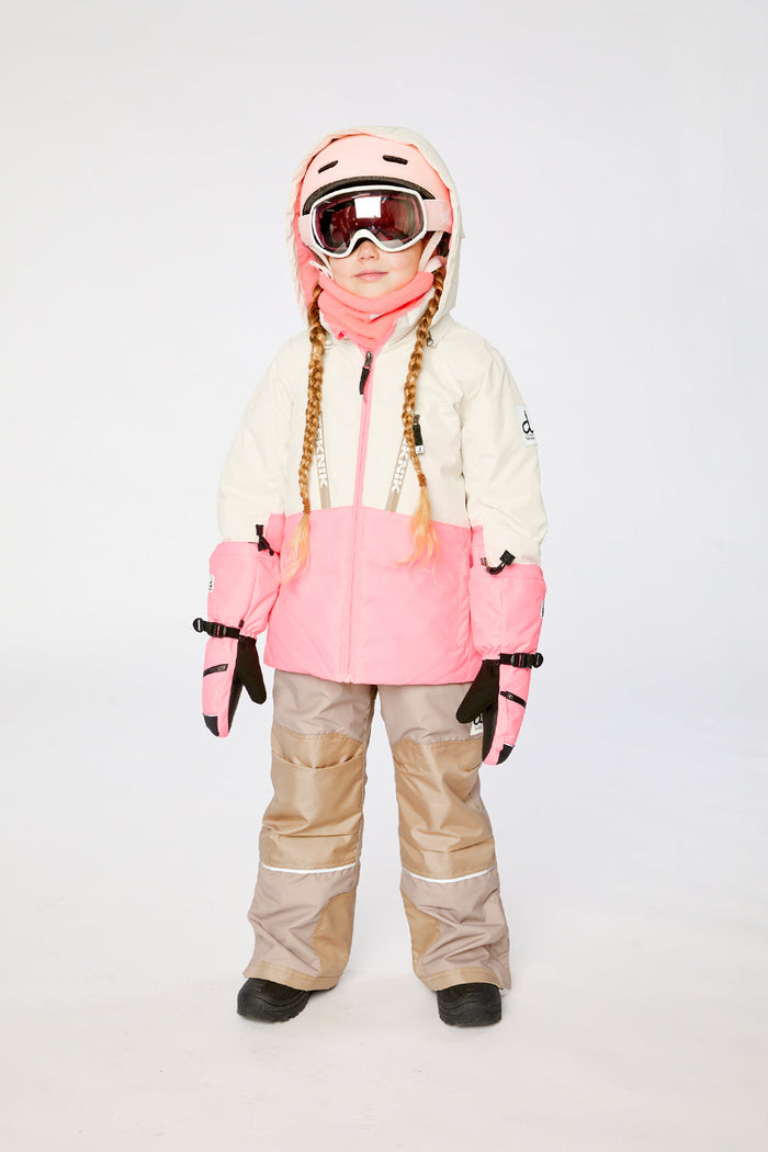 Child wearing the off-white and pink TEKNIK jacket and beige snow pants, front view