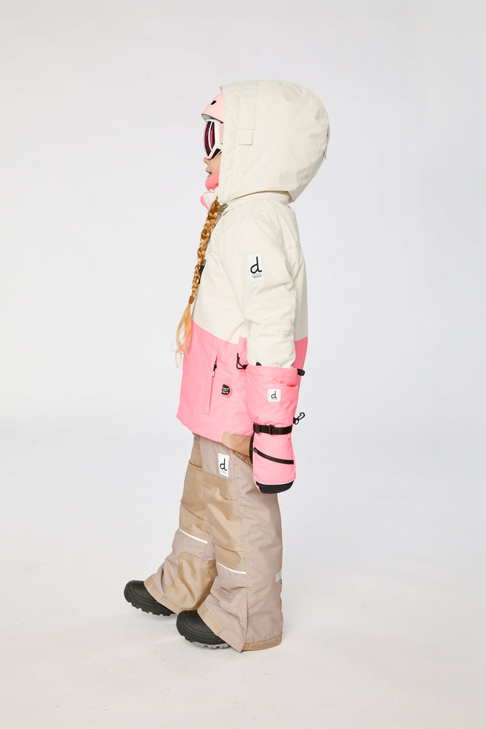 Child in the off-white and pink TEKNIK snowsuit, side profile view