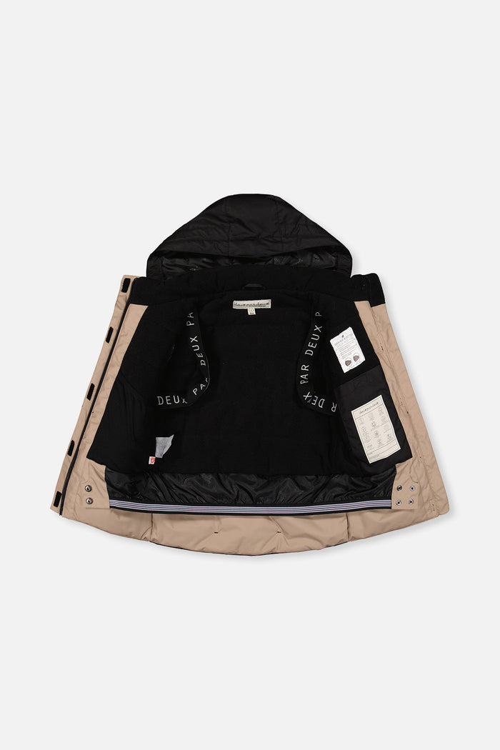 Black and beige TEKNIK jacket open to show the black fleece lining and backpack straps