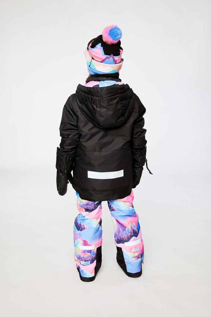 Deux par Deux girls' Teknik snowsuit, black jacket and pink-blue mountain print pants – on a child model, another view