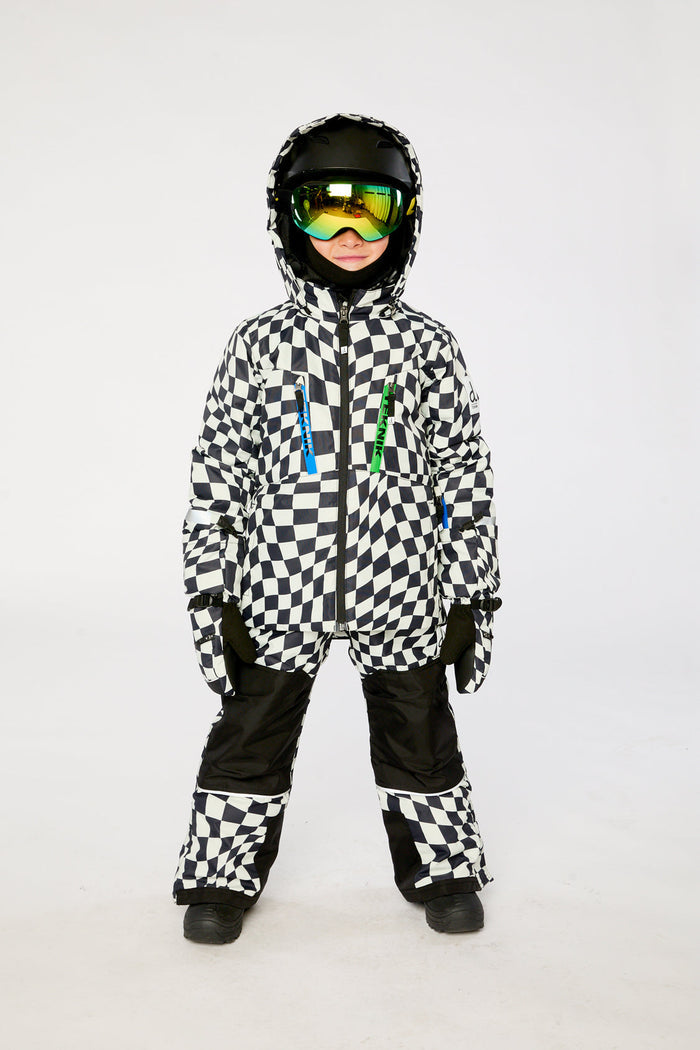 Child in the checkered TEKNIK snowsuit with helmet and goggles, front view