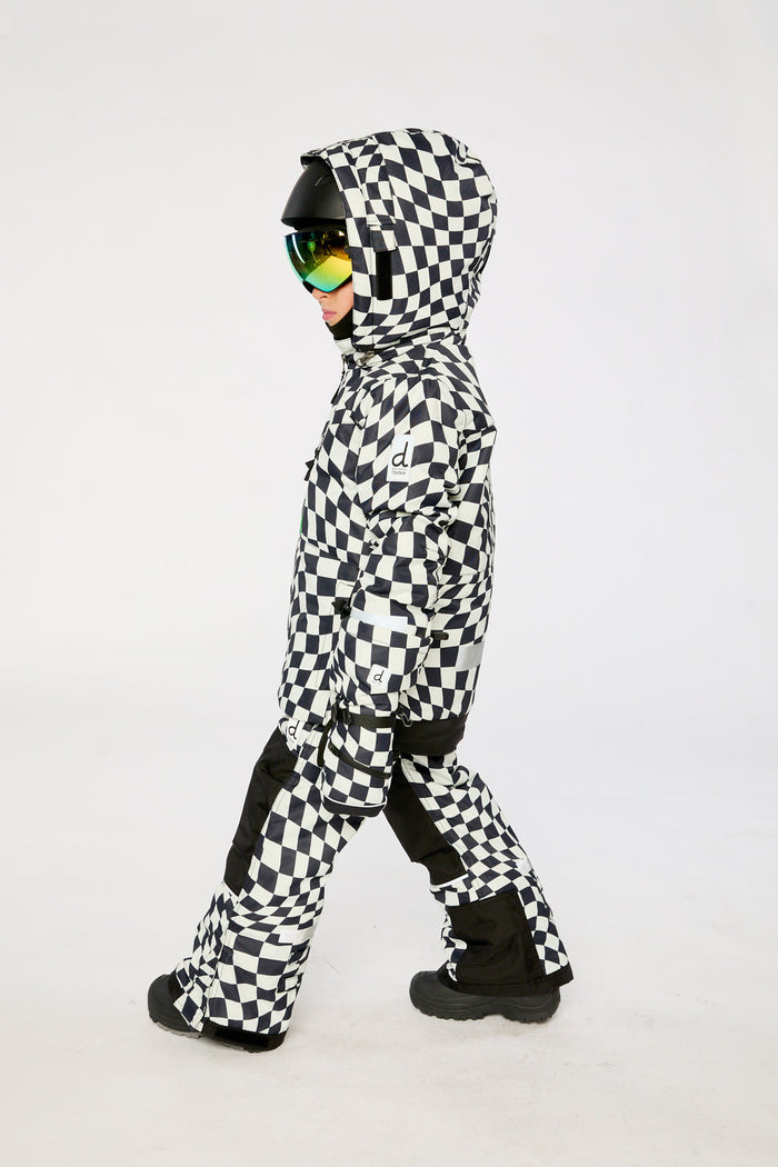 Child walking in the checkered TEKNIK snowsuit, side view