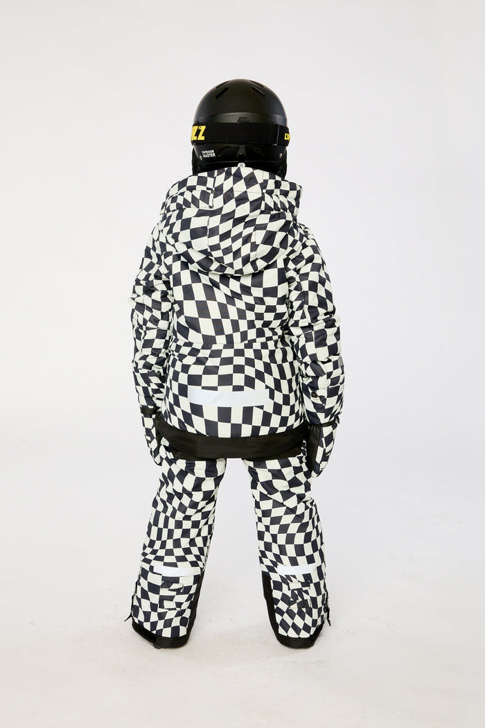 Child in the checkered TEKNIK snowsuit and helmet, back view