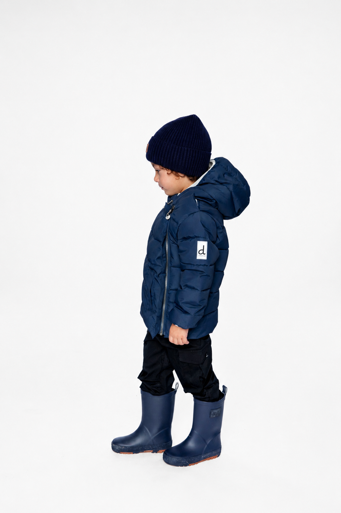 Child wearing the Deux par Deux dark blue car seat winter jacket, side view